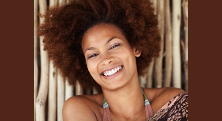 Closeup portrait of a pretty African American female against a bamboo wall