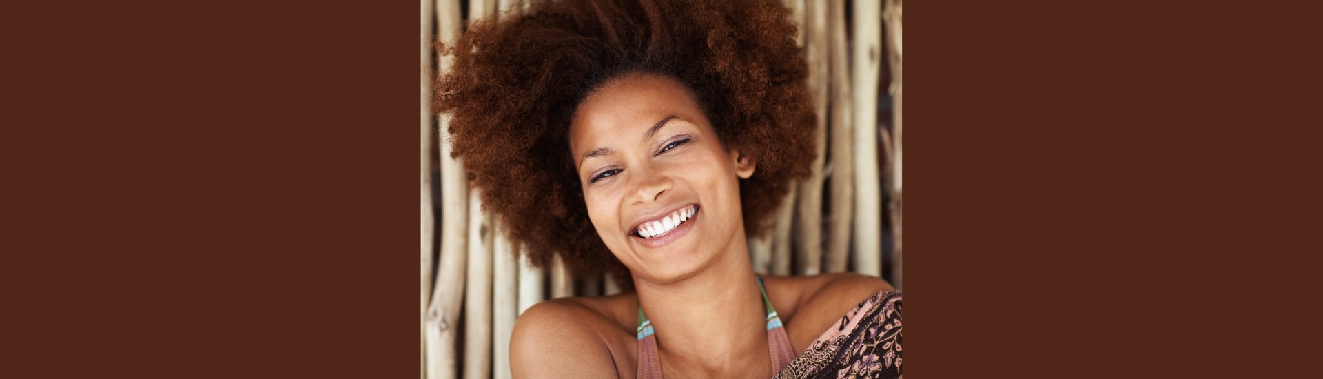 Closeup portrait of a pretty African American female against a bamboo wall